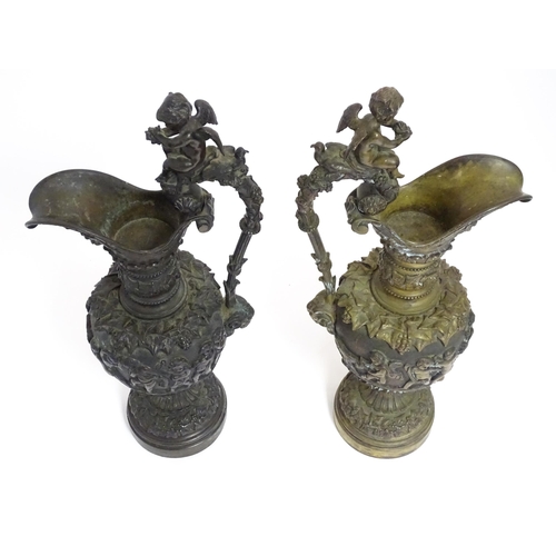 1230 - A pair of early 20thC cast ornamental ewers decorated in relief with fruiting vine and banded putti ... 