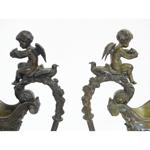 1230 - A pair of early 20thC cast ornamental ewers decorated in relief with fruiting vine and banded putti ... 