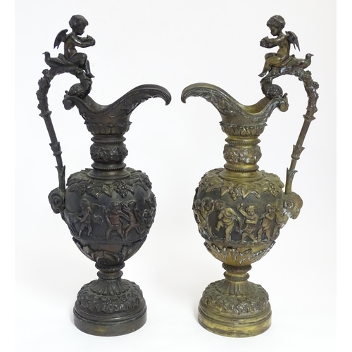 1230 - A pair of early 20thC cast ornamental ewers decorated in relief with fruiting vine and banded putti ... 