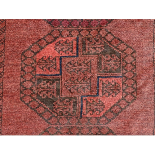 1355 - Carpet / Rug : A red ground rug with four central medallions decorated with geometric and foliate de... 