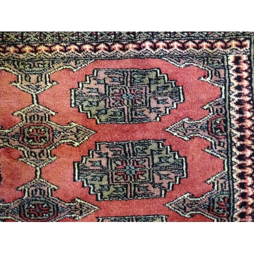 1356 - Carpet / Rug : A rug with salmon ground decorated with repeating motifs and banded borders. Approx. ... 