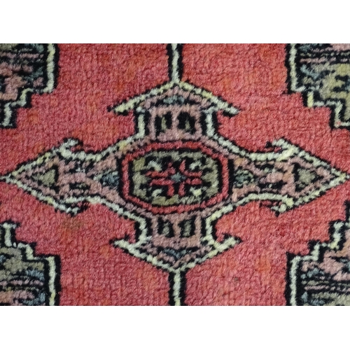 1356 - Carpet / Rug : A rug with salmon ground decorated with repeating motifs and banded borders. Approx. ... 