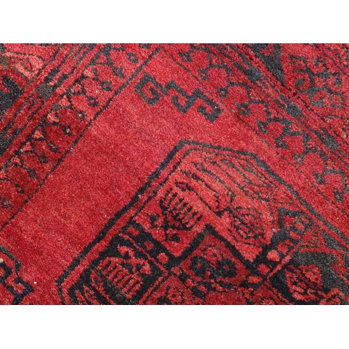 1362 - Carpet / Rug : A red ground rug with three central medallions decorated with geometric floral and fo... 