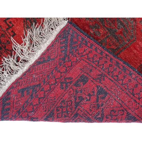 1362 - Carpet / Rug : A red ground rug with three central medallions decorated with geometric floral and fo... 