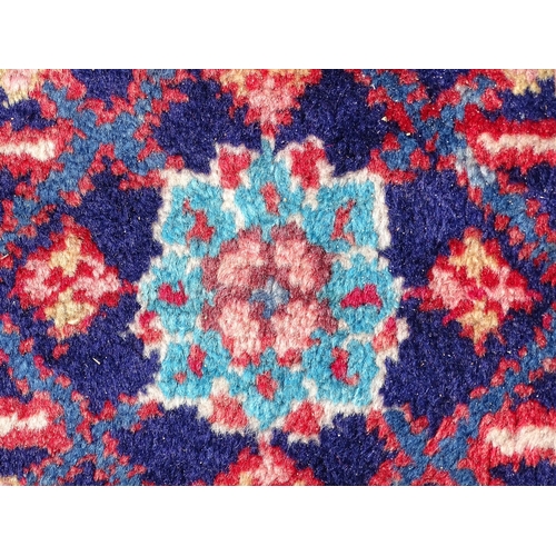 1368 - Carpet / Rug : A Persian rug the blue ground decorated with repeating floral motifs with central cre... 