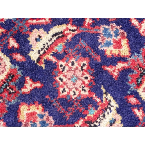 1368 - Carpet / Rug : A Persian rug the blue ground decorated with repeating floral motifs with central cre... 