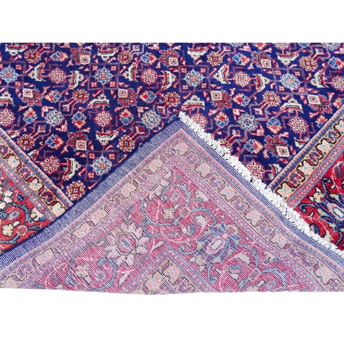 1368 - Carpet / Rug : A Persian rug the blue ground decorated with repeating floral motifs with central cre... 