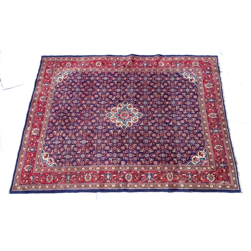 1368 - Carpet / Rug : A Persian rug the blue ground decorated with repeating floral motifs with central cre... 