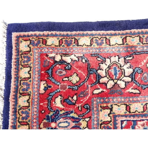 1368 - Carpet / Rug : A Persian rug the blue ground decorated with repeating floral motifs with central cre... 