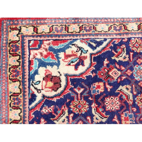 1368 - Carpet / Rug : A Persian rug the blue ground decorated with repeating floral motifs with central cre... 