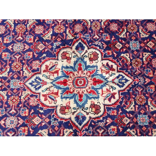 1368 - Carpet / Rug : A Persian rug the blue ground decorated with repeating floral motifs with central cre... 