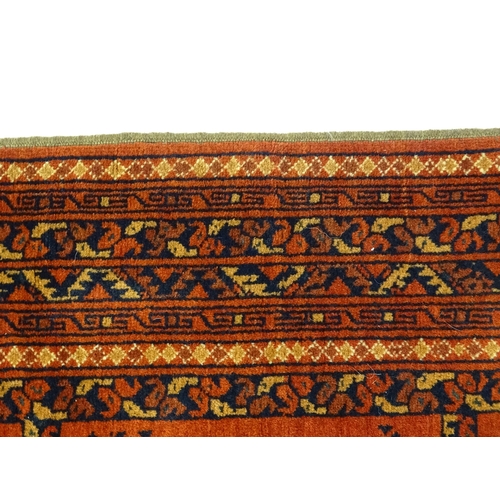 1379 - Carpet / Rug : A rug having orange red ground decorated with repeating geometric, floral and foliate... 