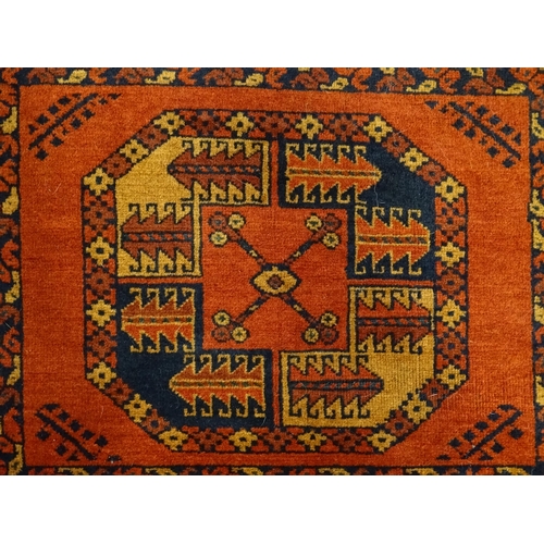 1379 - Carpet / Rug : A rug having orange red ground decorated with repeating geometric, floral and foliate... 