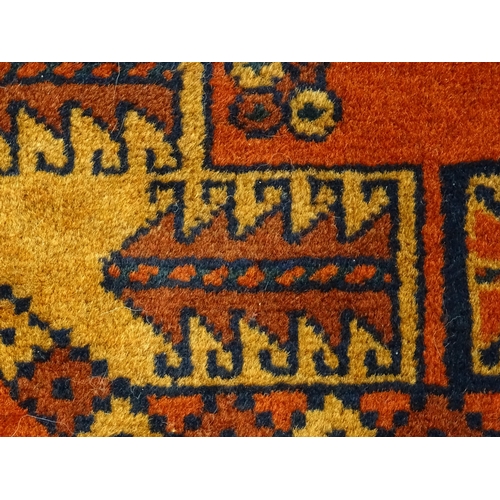 1379 - Carpet / Rug : A rug having orange red ground decorated with repeating geometric, floral and foliate... 