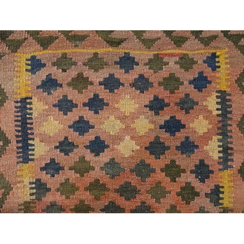 1381 - Carpet / Rug : A rug having salmon ground decorated with repeating geometric motifs. Approx 41