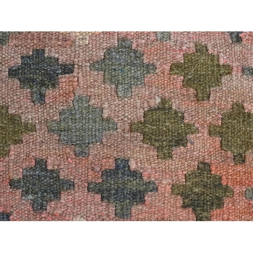 1381 - Carpet / Rug : A rug having salmon ground decorated with repeating geometric motifs. Approx 41