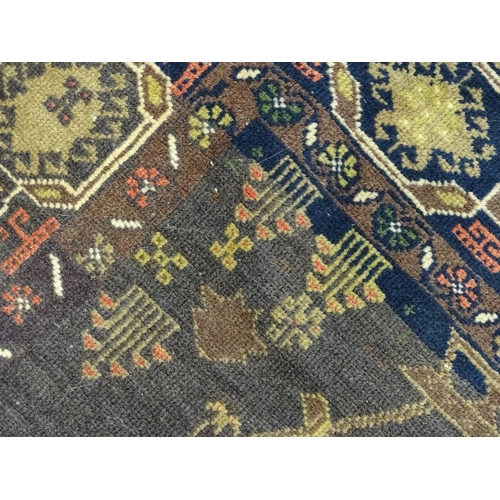 1382 - Carpet / Rug : A rug with dark ground decorated with two stylised vases bordered by floral, foliate ... 