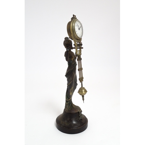 1403 - A Junghans Mystery ( swinging) clock  formed as a spelter lady holding aloft a clock suspended from ... 