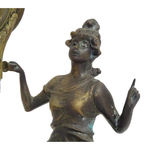 1403 - A Junghans Mystery ( swinging) clock  formed as a spelter lady holding aloft a clock suspended from ... 