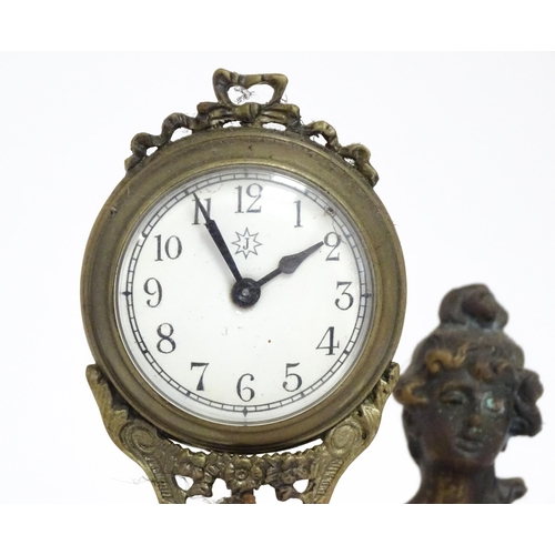 1403 - A Junghans Mystery ( swinging) clock  formed as a spelter lady holding aloft a clock suspended from ... 