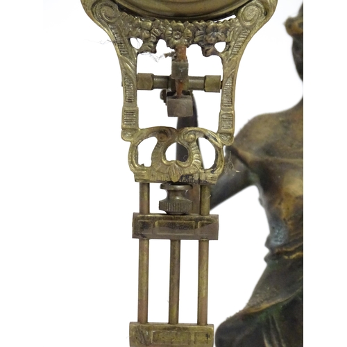 1403 - A Junghans Mystery ( swinging) clock  formed as a spelter lady holding aloft a clock suspended from ... 