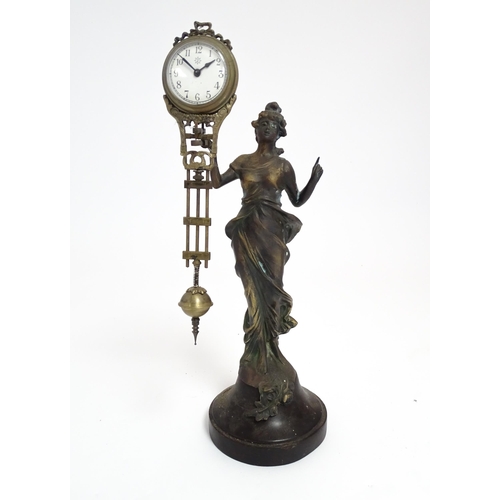 1403 - A Junghans Mystery ( swinging) clock  formed as a spelter lady holding aloft a clock suspended from ... 