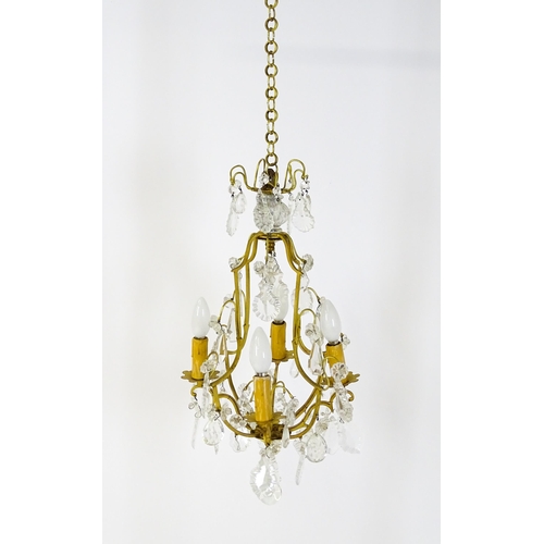 1438 - A 20thC French hanging pendant electrolier having four branches and hanging lustres. Approx. 21