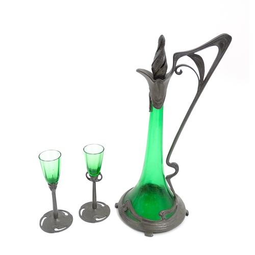 1012 - An Art Nouveau green glass and pewter decanter and two pedestal glasses with tendril detail. In the ... 