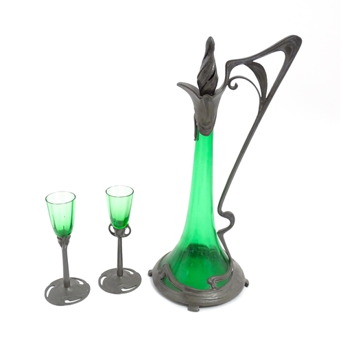 1012 - An Art Nouveau green glass and pewter decanter and two pedestal glasses with tendril detail. In the ... 