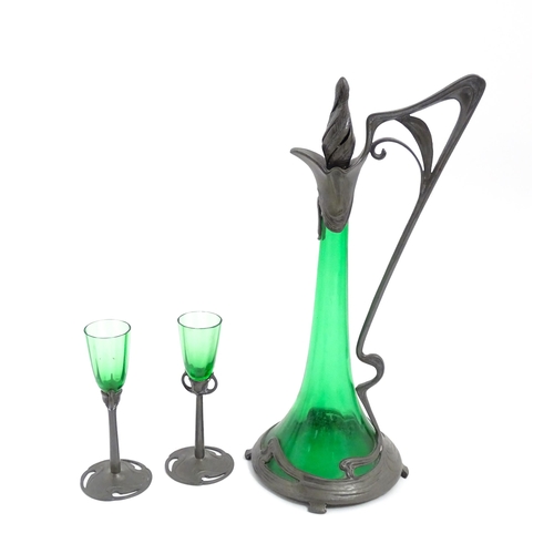 1012 - An Art Nouveau green glass and pewter decanter and two pedestal glasses with tendril detail. In the ... 