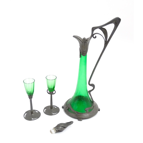 1012 - An Art Nouveau green glass and pewter decanter and two pedestal glasses with tendril detail. In the ... 