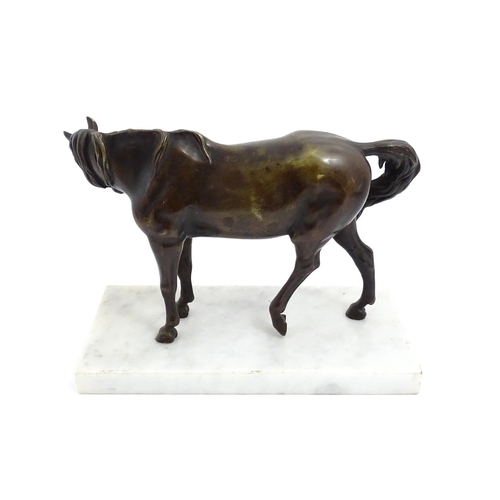 1015 - A 20thC cast sculpture modelled as a standing horse, raised on a marble base. Approx. 7 1/4