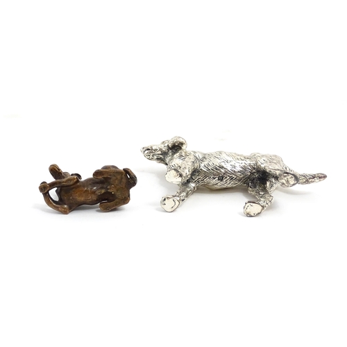 1017 - A small late 19th / early 20thC bronze model of a dog / hound. Together with a silver plate model of... 