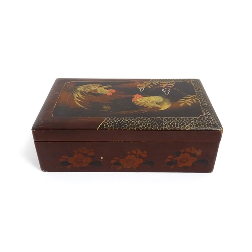 1032 - An Oriental lacquered box with hand painted cockerel decoration, opening to reveal inlaid marquetry ... 