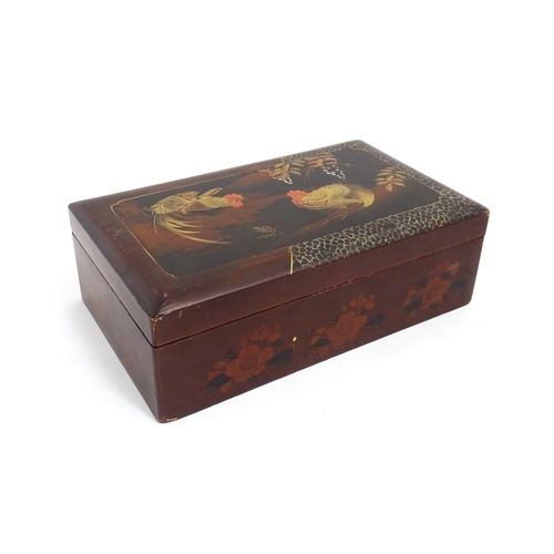 1032 - An Oriental lacquered box with hand painted cockerel decoration, opening to reveal inlaid marquetry ... 