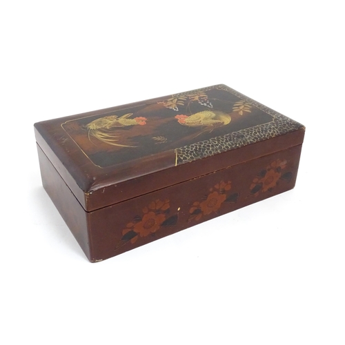 1032 - An Oriental lacquered box with hand painted cockerel decoration, opening to reveal inlaid marquetry ... 