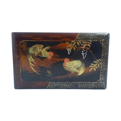 1032 - An Oriental lacquered box with hand painted cockerel decoration, opening to reveal inlaid marquetry ... 