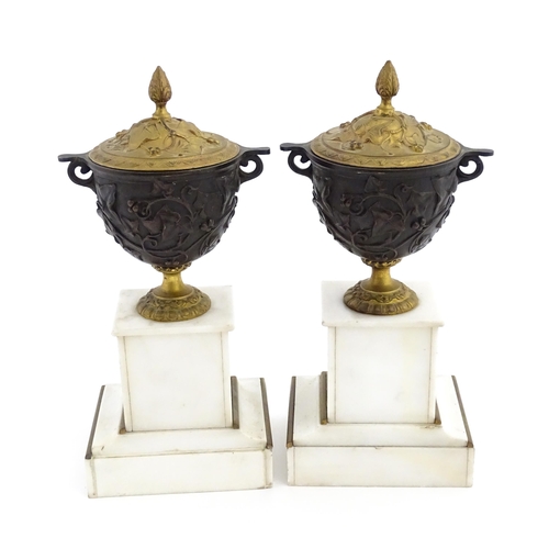 1059 - A pair of late 19th / early 20thC cast lidded urns with scrolling vine decoration, each raised on a ... 