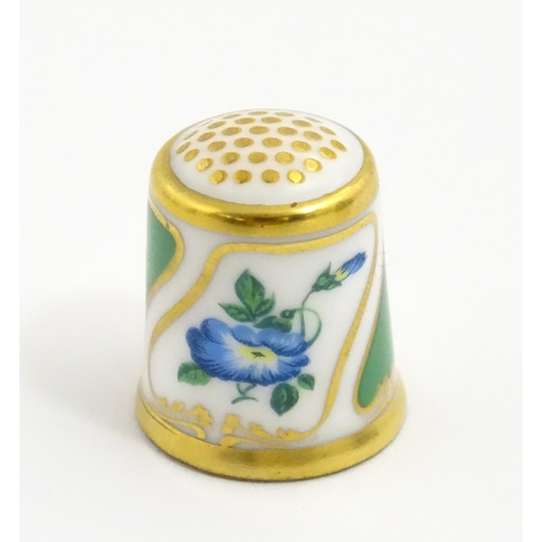 1064 - Fifteen Royal Crown Derby porcelain thimbles in various patterns, displayed on a turned wooden two t... 