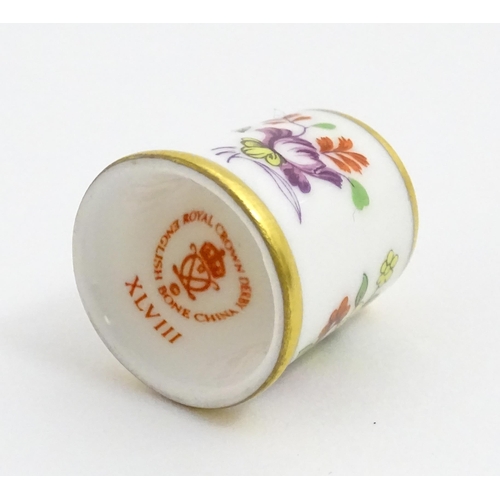 1064 - Fifteen Royal Crown Derby porcelain thimbles in various patterns, displayed on a turned wooden two t... 