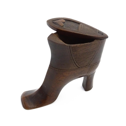 1151 - Treen : A large 19thC shoe snuff box / table snuff of heeled boot form with pivoting lid and carved ... 