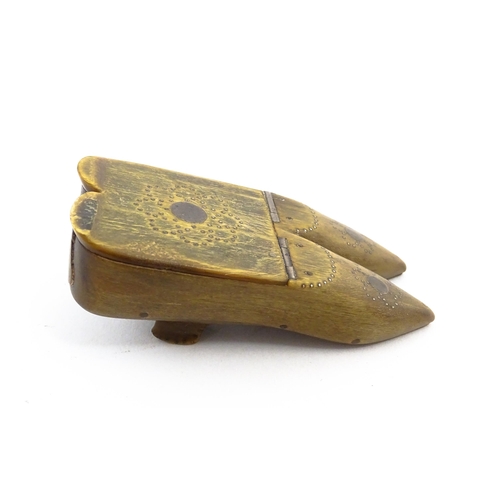 1158 - A 19thC horn double shoe snuff box modelled as a pair of shoes with hinged top and inlaid brass stud... 