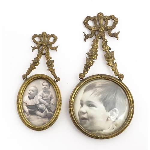 1189 - Two small early 20thC brass frames, one of circular form, the other oval, both with floral swag deco... 