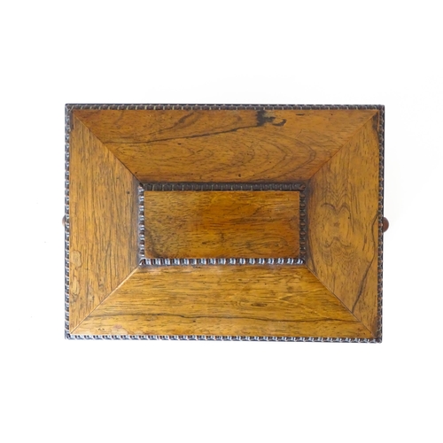 1194 - A Victorian rosewood sewing box / workbox of sarcophagus form with twin ring handles, opening to rev... 