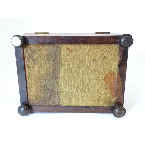 1194 - A Victorian rosewood sewing box / workbox of sarcophagus form with twin ring handles, opening to rev... 