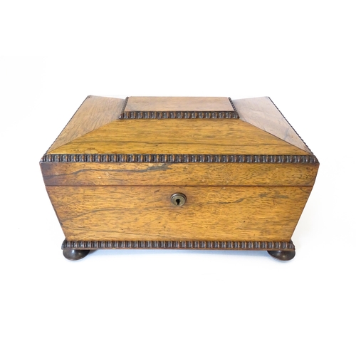 1194 - A Victorian rosewood sewing box / workbox of sarcophagus form with twin ring handles, opening to rev... 