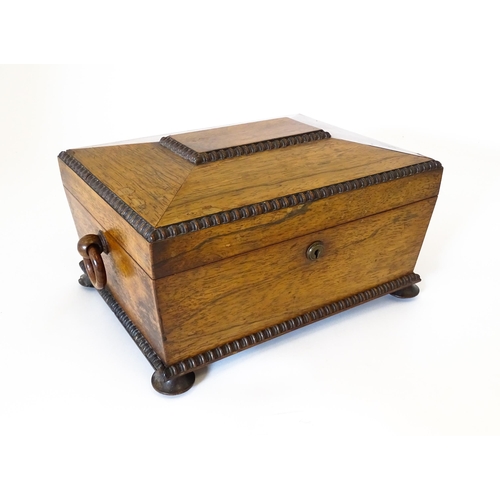 1194 - A Victorian rosewood sewing box / workbox of sarcophagus form with twin ring handles, opening to rev... 