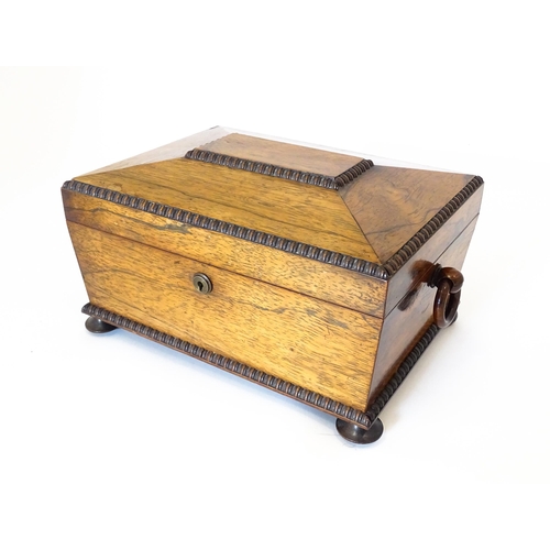 1194 - A Victorian rosewood sewing box / workbox of sarcophagus form with twin ring handles, opening to rev... 