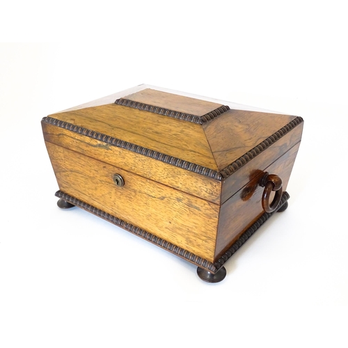 1194 - A Victorian rosewood sewing box / workbox of sarcophagus form with twin ring handles, opening to rev... 