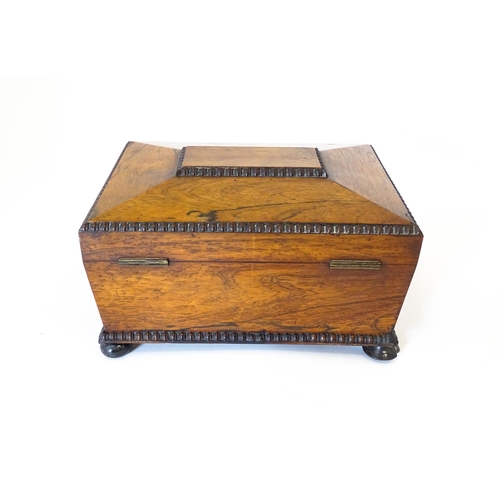 1194 - A Victorian rosewood sewing box / workbox of sarcophagus form with twin ring handles, opening to rev... 